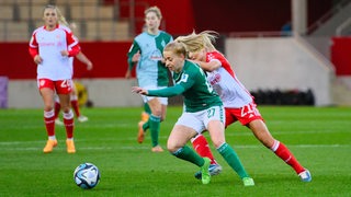 Die Werder-Spielerin Nina Lührßen setzt sich gegen eine Bayern-Gegenspielerin durch.