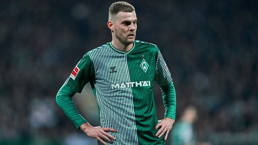 Werder-Stürmer Marvin Ducksch steht konsterniert und mit den Händen in den Hüften nach dem Spiel auf dem Platz.