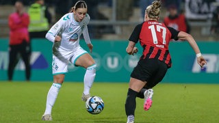 Zwei Fußballspielerinnen mit einem Ball spielen Fußball.