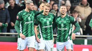 Die Werder-Profis Marvin Ducksch und Mitchell Weiser bejubeln mit Marco Grüll dessen Treffer gegen Berlin.