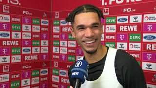 Werder-Torschütze Justin Njinmah strahlt beim Interview nach dem Sieg in Köln.