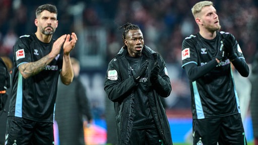 Werders Fußball-Profis Anthony Jung, Issa Kaboré und Marvin Ducksch applaudieren nach der Niederlage in Leipzig ernüchtert den Fans.