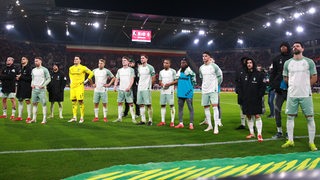 Werders Fußballprofis stehen nach der 0:5-Klatsche in Freiburg frustriert nebeneinander vor dem Bremer Fanblock.