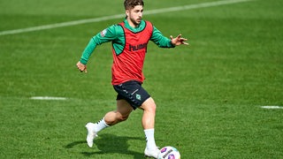 Werder-Spieler Romano Schmid spurtet während des Trainings mit dem Ball.