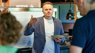 Thomas Gutzeit, zuständig für das Catering im Weserstadion, hält einen Teller in der Hand.