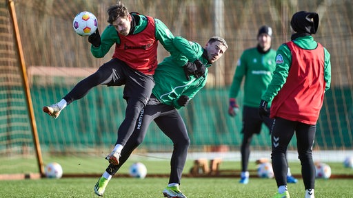 Werder-Spieler beim Training, Kapitän Marco Friedl und Stürmer Dawid Kownacki im robusten Zweikampf.