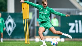 Werder-Stürmer Niclas Füllkrug tritt während des Trainingslagers mit weit ausgebreiteten Armen dynamisch gegen den Ball.