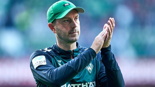 Werder-Trainer Ole Werner applaudiert im Stadion den Bremer Fans.