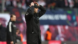 Werder-Trainer Ole Werner legt am Rande des Spiels in Leipzig  frustriert die Hände auf den Kopf.