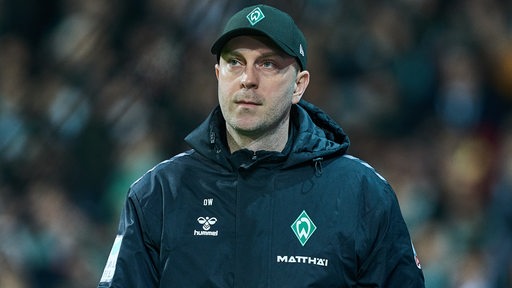 Werder-Trainer Ole Werner schaut nachdenklich im Weser-Stadion auf dem Weg zur Trainerbank.