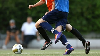 Zwei Spieler im Zweikampf um den Ball. 