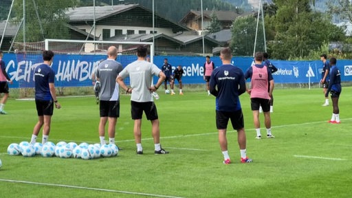 Männer auf einem Fußballplatz.