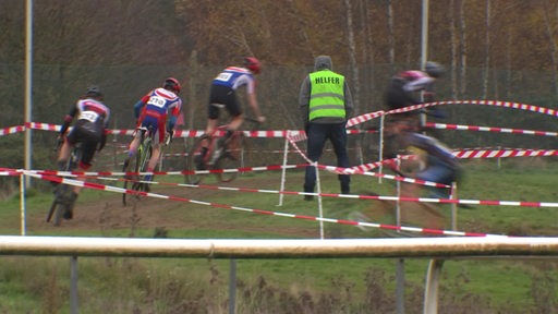 Ein Helfer steht am Rennbahnrand der Galopprennbahn Hemelingen beim Galoppcross.