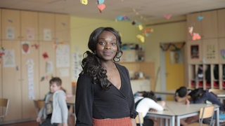 Eine Lehrerin steht im Klassenzimmer 