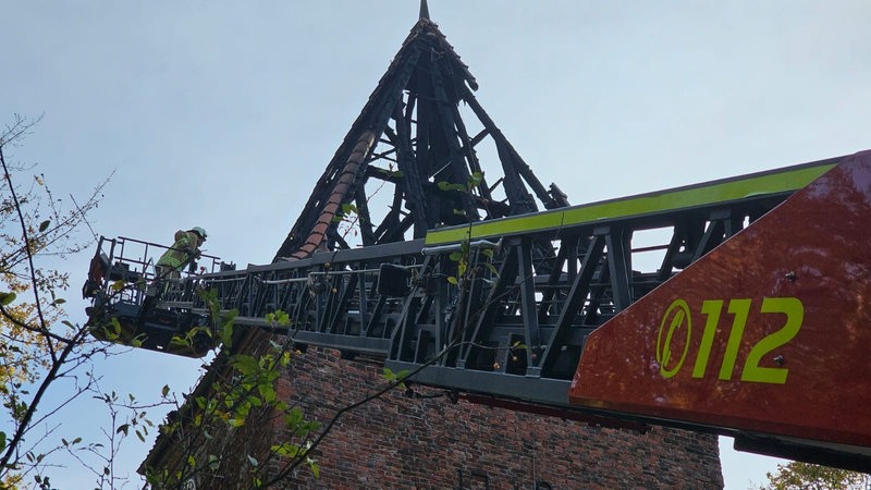 Ein Feuerwehrkran neben einem Glockenturm.