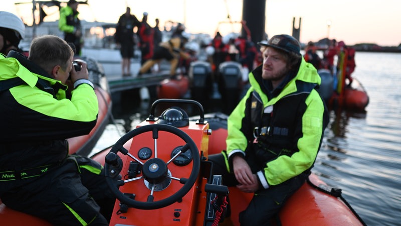 Greenpeace-Aktivisten sitzen auf einem Schlauchboot.