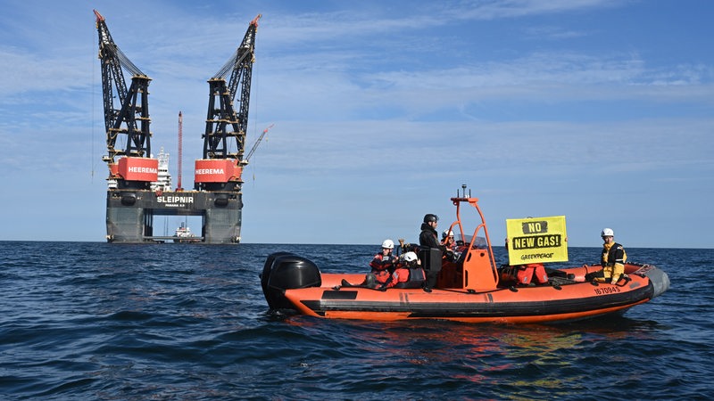 Ein Schlauchboot von Greenpeace mit einem "No new Gas!"-Banner fährt vor der Bohrinsel in Borkum.