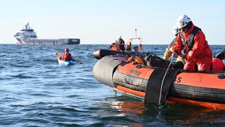 Aktivisten bringen eine Kette als Sicherung für die Rettungsinseln ins Wasser. Greenpeace-Aktivisten protestieren rund 20 Kilometer nordwestlich der Insel Borkum gegen die Förderung von Erdgas. 