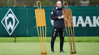 Werder-Trainer Ole Werner stellt beim Training Freistoßmännchen auf.