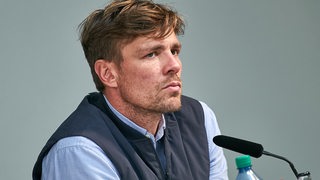 Clemens Fritz schaut leicht genervt auf dem Podium.