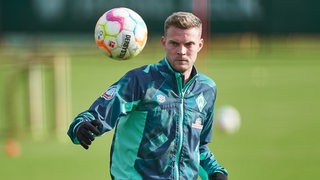 Werder-Stürmer Marvin Ducksch fixiert beim Individualtraining den bunten Fußball.