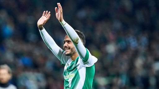 Leonardo Bittencourt winkt freudig im Werder-Trikot. 