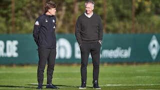 Die Werder-Verantwortlichen Clems Fritz und Frank Baumann schauen über den Trainingsplatz.