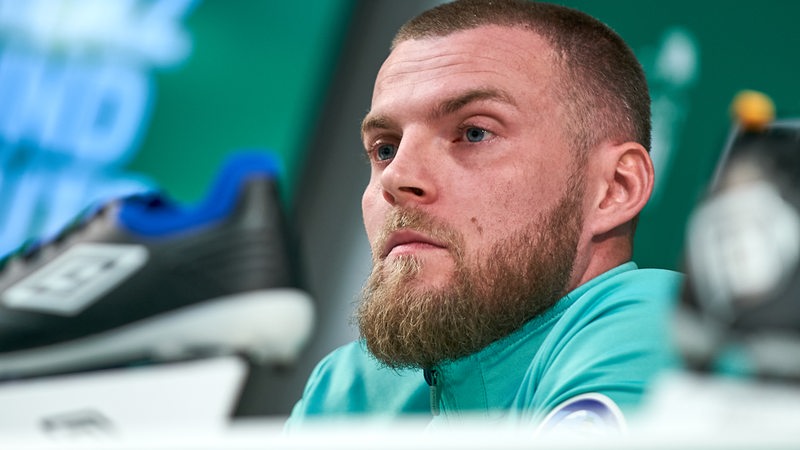 Werder-Stürmer Marvin Ducksch sitzt bei einer Pressekonferenz nachdenklich auf dem Podium.