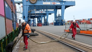 Zwei Männer befestigen ein Schiff in Bremerhaven