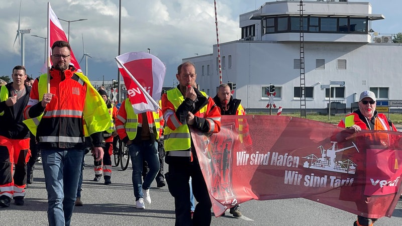 Menschen in gelben Warnwesten bei einem Demonstrationszug.