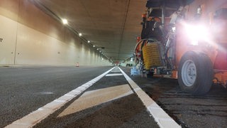 Ein Baufahrzeug steht in einem leeren Tunnel.