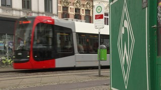 Die Bahn der Linie 3 an der St. Jürgen Haltestelle im bremer Viertel. Rechts im Bild eine Werder Raute.