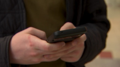 Jemand hält sein Handy in den Händen.