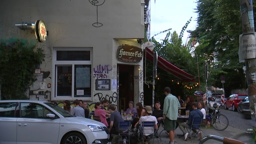 Viele Menschen sitzen an Tischen vor der Eckkneipe "Horner Eck"