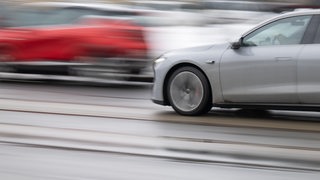 Zwei Autos fahren mit hoher Geschwindigkeit auf einer Straße.