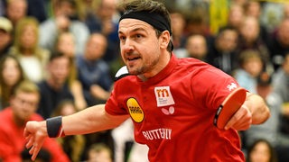 Tischtennis-Spieler Timo Boll bei einer weiten Ausholbewegung am Tisch.