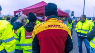 Ein DHL-Mitarbeiter beteiligt sich an einem Warnstreik.