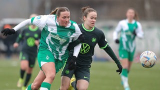 Werder-Stürmerin Stefanie Sanders im Zweikampf mit einer Wolfsburger Spielerin im Testspiel.