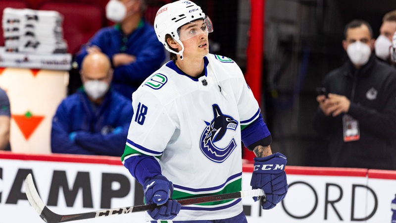 Eishockey-Spieler Jake Virtanen hält seinen Schläger in den Händen.