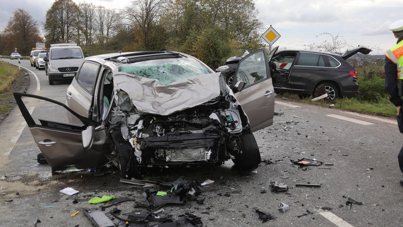 Heck von Auto nach Unfall auf Straße zerstört, beteiligte Wagen stehen am Straßenrand