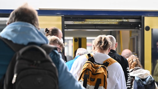 Fahrgäste steigen in eine Nordwestbahn ein (Archivbild)