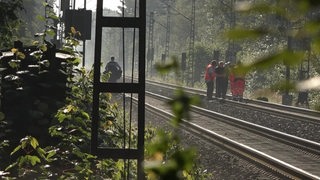 Ermittler an der wegen Vandalismus beschädigten Bahnstrecke.