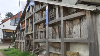 Ein großes, selbst gebautes Insektenhotel aus Holz.