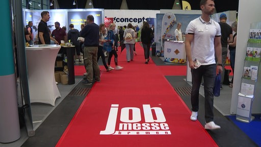 Viele Besucherinnen und Besucher laufen über das Gelände der Job Messe Bremen mit vielen Messeständen.