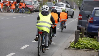 Kinder einer Grundschule machen eine Fahrradprüfung und fahren mit Sicherheitsweste .