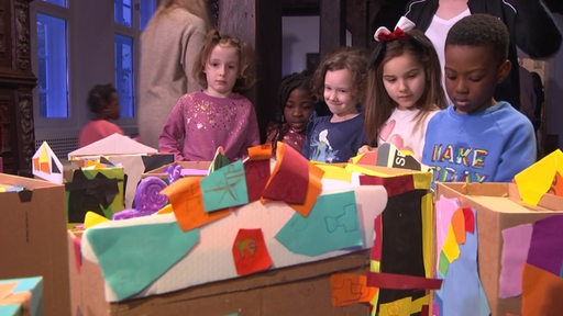 Mehrere Kinder stehen um bunte Ausstellungen im Focke-Museum herum.