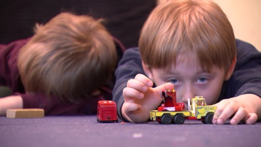 Kinder am spielen mit einem kleinen Spielzeugauto.