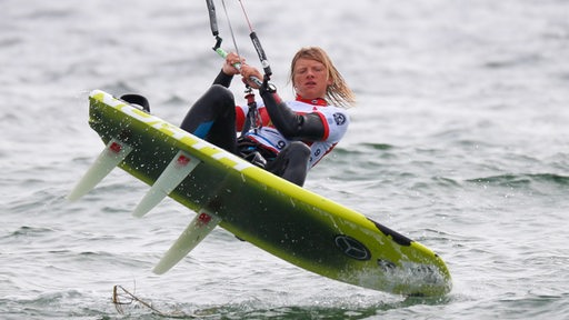 Jannis Maus beim Kitesurfen auf dem Wasser. 