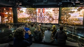 Museumsmitarbeitersitzen auf der Erlebnisplattform während einer Vorab-Besichtigung der geplanten Ausstellung "Wetterextreme" im Klimahaus in Bremerhaven.