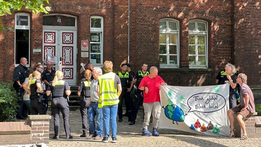 Klima-Demonstranten und Polizisten vor dem Amtsgericht in Achim